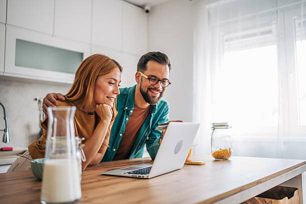istock Couple doing online shopping with credit card in kitchen 2229580752