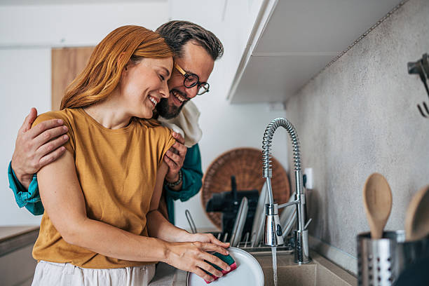 istock Couple washing dishes together in modern kitchen 2229581716