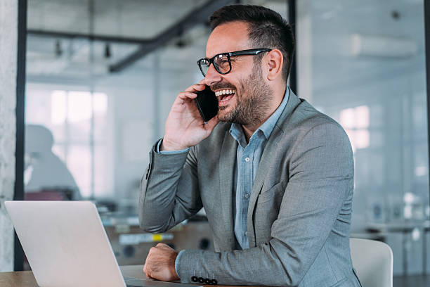 istock Businessman working on laptop and talking on cellphone. 2229582480