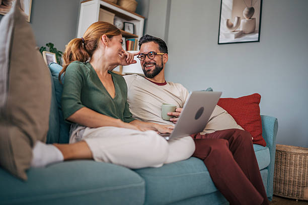 istock Couple relaxing on sofa, browsing internet and enjoying coffee 2229582722