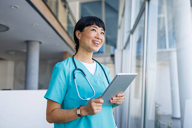 istock Smiling doctor using digital tablet in modern hospital 2229583414