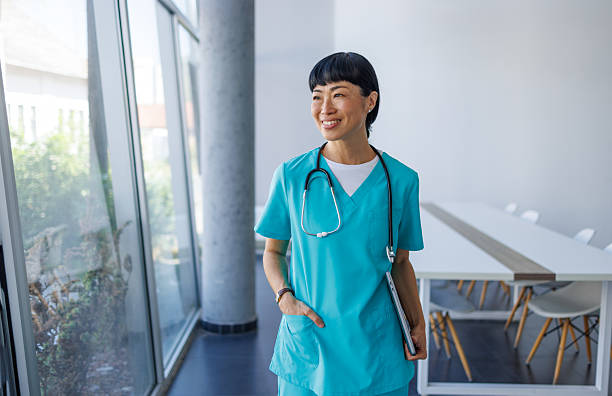 istock Smiling doctor walking through hospital corridor holding tablet 2229583447