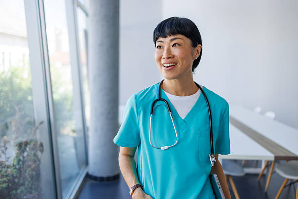 istock Smiling doctor walking through hospital corridor holding tablet 2229583638