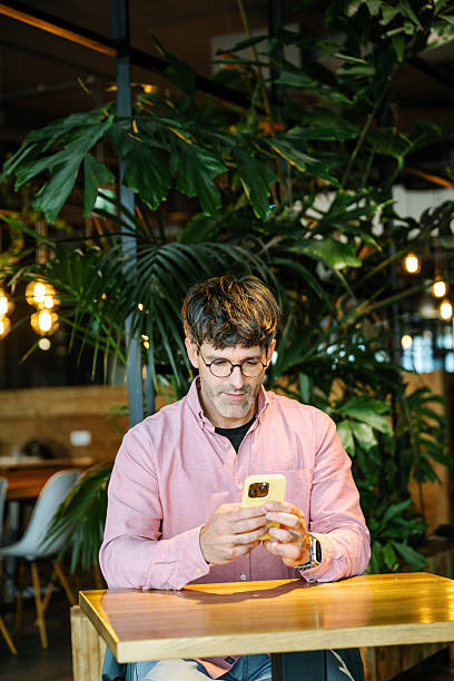 istock Serious businessman working remotely on laptop in cozy cafe environment while scrolling through the website 2229587282