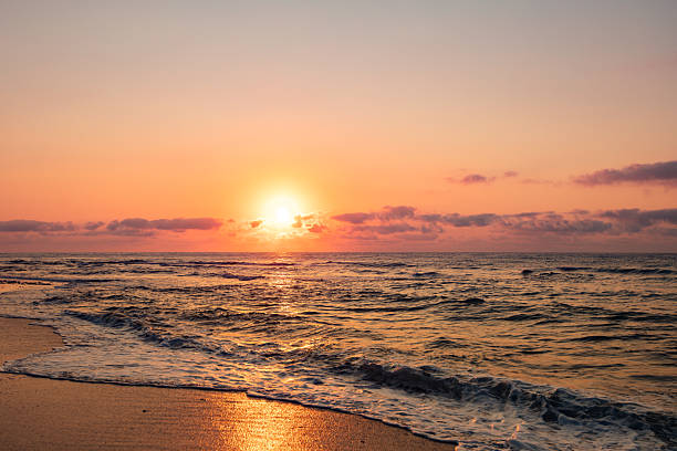 istock Dramatic sunset over the sea with orange sky and waves 2229590352