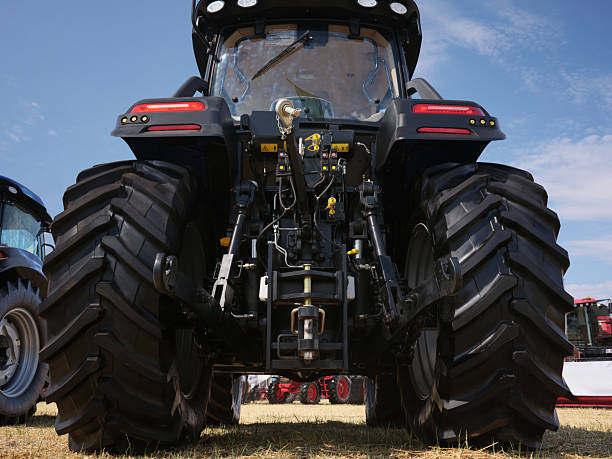 istock Rear view large modern tractor standing in a field. Auxiliary nodes for connecting various equipment. 2229590411
