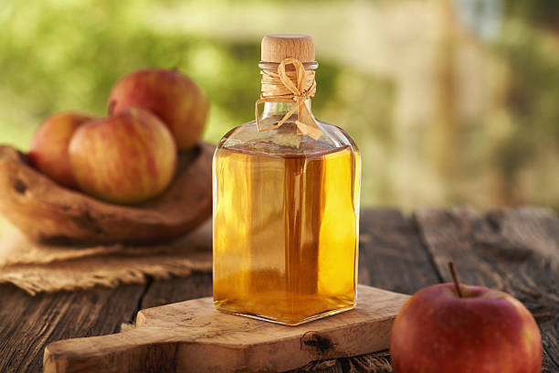 istock Apple cider vinegar in a glass bottle on a table outdoors 2229590689
