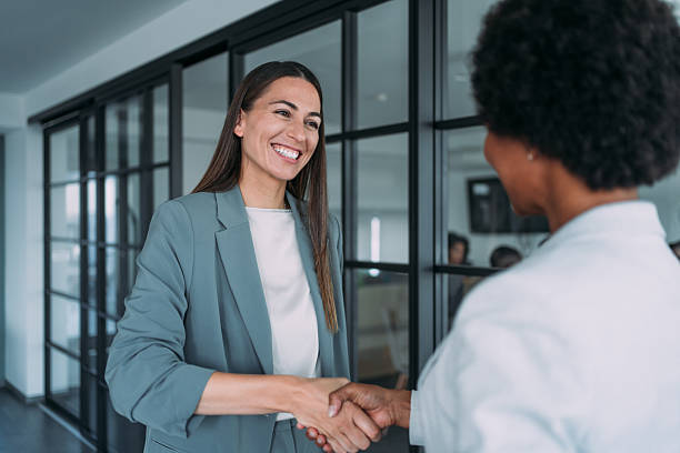 istock Business persons shaking hands in office corridor. 2229590999