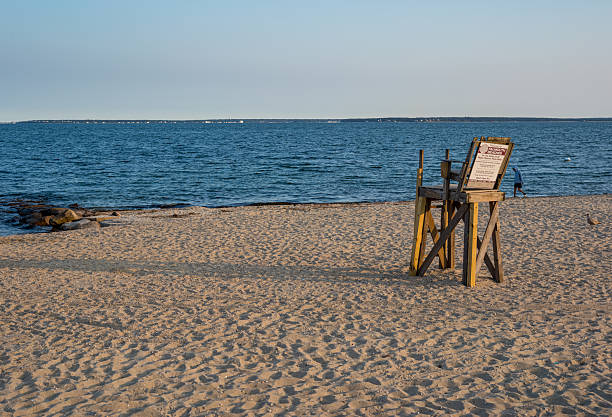 Early evening on the Falmouth Heights beach in Falmouth, MA on Cape Cod an empty lifeguard chair sits waiting for the next day which will be busy on the beach.  The chair is overlooking Vineyard Sound and the beach is one of the most popular beaches in Falmouth, MA.