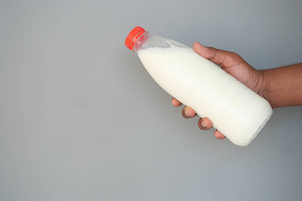 istock Holding a bottle of fresh milk against a neutral background 2229594705