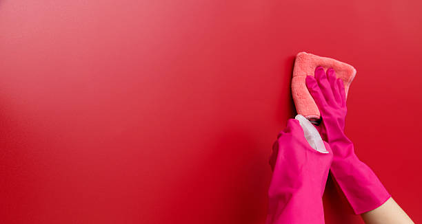 istock Woman hand cleaning red wall with rag 2229595717