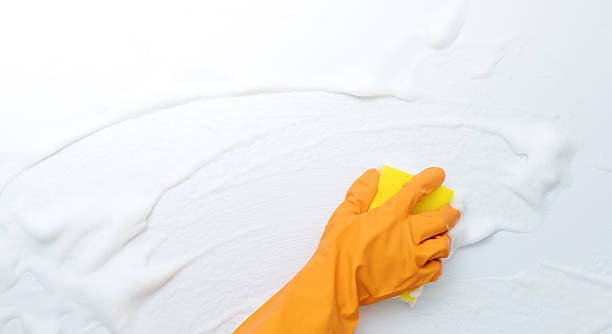 istock Woman hand cleaning blue wall with sponge 2229595742