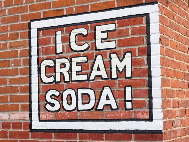 Ice cream soda sign on side of brick building. A favorite refreshing summer time treat and a sign inviting you to partake.