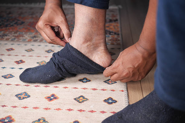 istock Person putting on sock in cozy indoor setting 2229599646