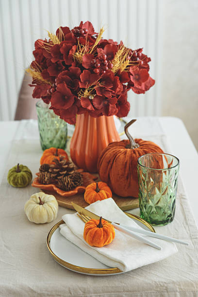 istock Thanksgiving table setting with decorative pumpkins, candles and string lights on white wooden table 2229604355