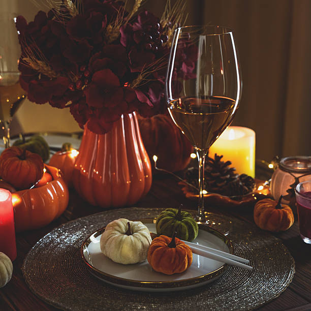 istock Thanksgiving table setting with decorative pumpkins, candles and string lights on dark wooden table 2229604377