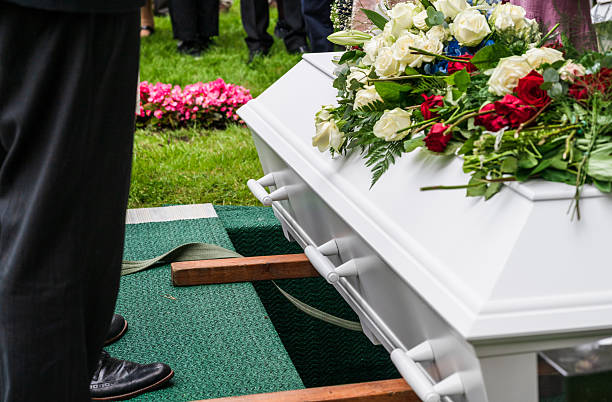 istock Mourners standing beside coffin near grave. 2229604511