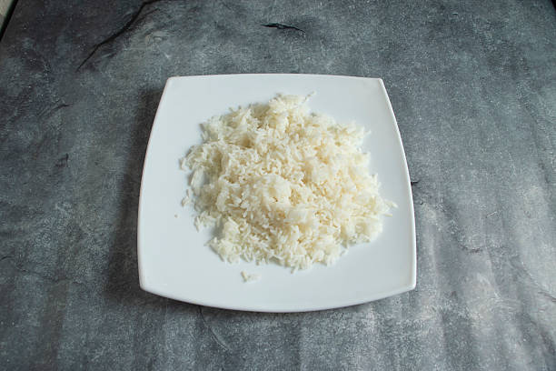 istock Plain White Steamed Rice Served on White Plate Over Gray Stone Background Top View 2229605653