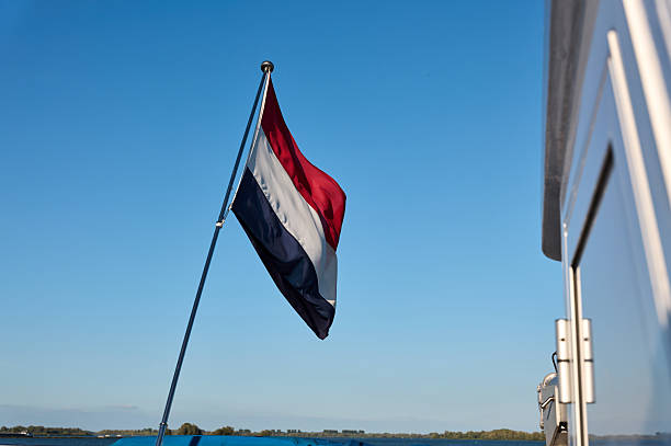 Netherlands flag waving from a boat sailing on a lake
