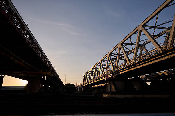 istock Train tracks crossing industrial bridge at sunset 2229608945