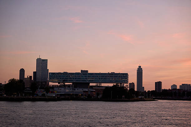 Rotterdam city skyline reflecting on the nieuwe maas at sunset with erasmusbrug and de rotterdam buildings