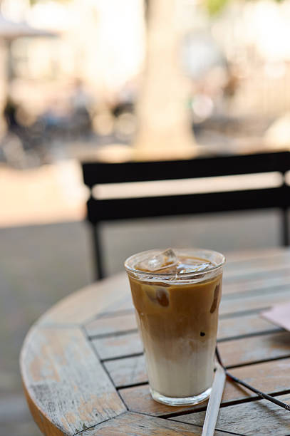 Refreshing iced latte sitting on a wooden table at a cafe
