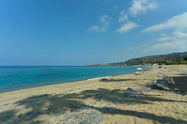 istock Sunny beach with clear blue water and distant hills. 2229613727