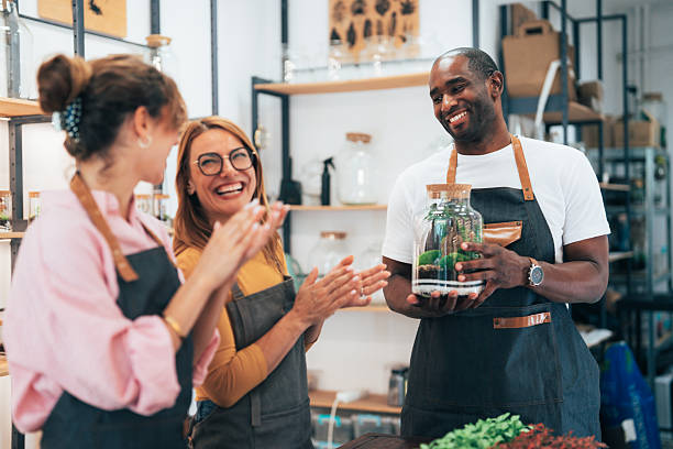 istock Young florist assisting students in assembling a plant terrarium at workshop 2229618426
