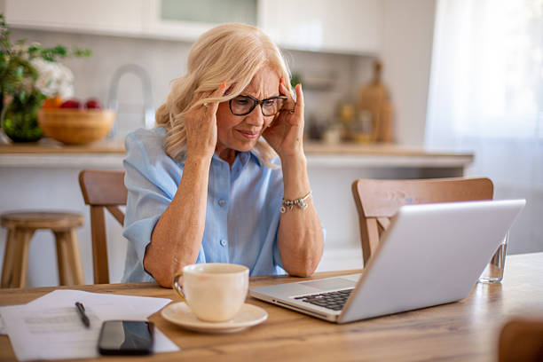 istock Senior woman suffering headache while working from home 2229622533