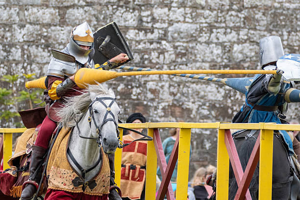 Fort George, Scotland - 10th Aug 2025: Men dressed as medieval knights jousting during a reenactment event at Fort George, Scotland.  During the event, people dressed as knights and other medieval characters perform jousts on horseback and battle using replica weapons and armour, and demonstrate various skills and work based on medieval techniques.Such events are a popular attraction for both tourists and locals during the summer season.