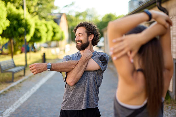 Couple stretching arms before running in the city