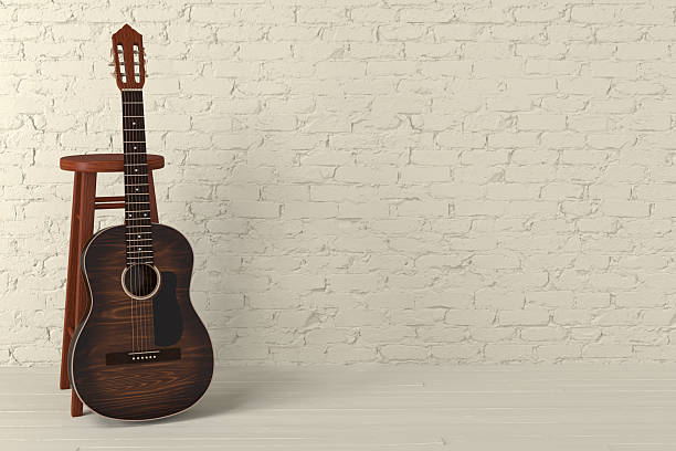 istock Brown classical guitar and chair near light yellow brick wall 2229626583