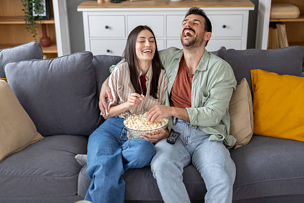 istock Couple Sharing a Joyful Time with Popcorn on the Couch 2229628159