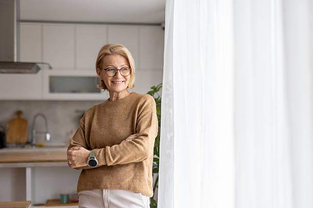 istock Confident older woman smiling near a bright window 2229628740