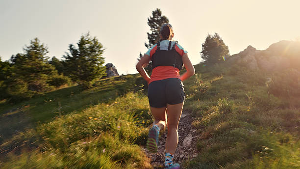 istock Female Runner Sprints on Scenic Trail in Athletic Gear 2229629179