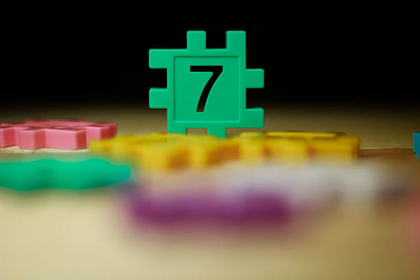 colorful puzzle block with number made from Plastic isolated in black with bokeh background.