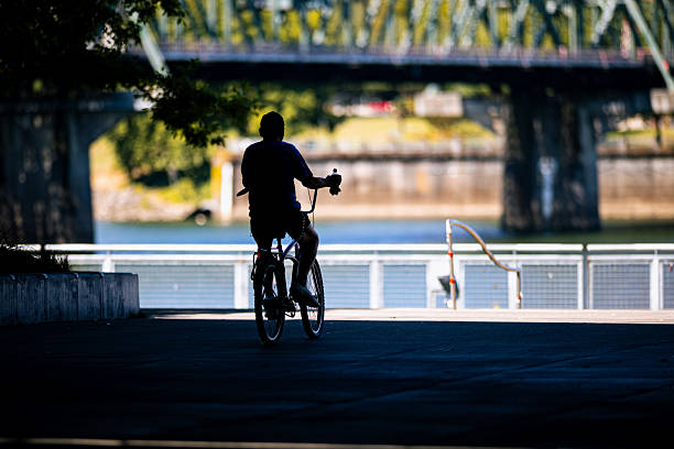Unrecognizable people in silhouette riding bikes in the city. Shot in Downtown Portland Oregon, Pacific Northwest.