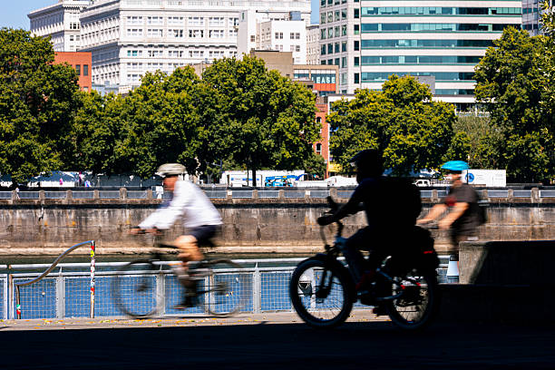 Unrecognizable people in silhouette riding bikes in the city. Shot in Downtown Portland Oregon, Pacific Northwest.