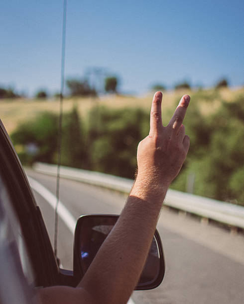 istock Peace Sign from Car Window on Road Trip 2229646728