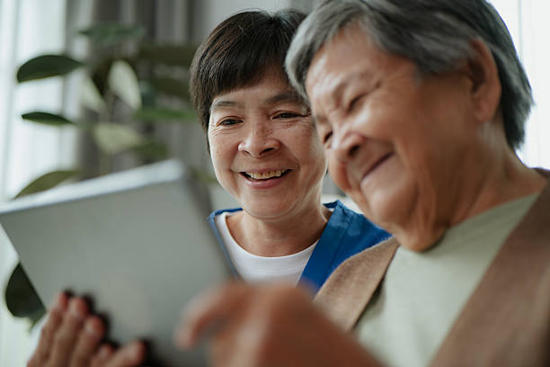 istock Elderly and caregiver using digital tablet. 2229655699