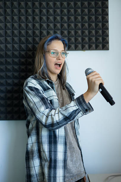 istock Confident Teen Girl with Microphone in Recording Studio 2229657104