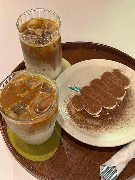 A delightful assortment of desserts displayed in a cozy cafe setting, featuring cakes, pastries, and sweet treats on elegant plates, creating a warm and inviting atmosphere.