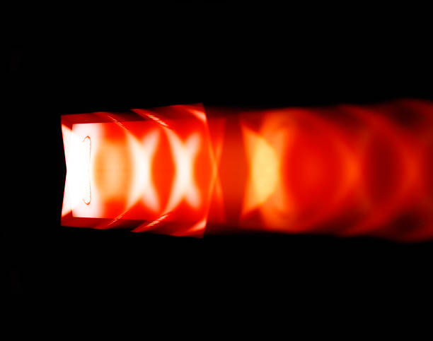 A night lamp with an electric charge shines with a lilac light at a long exposure with smooth blurred discharge movements, Close-up side view.