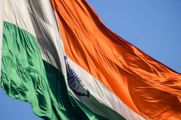 istock India flag flying high at Connaught Place with pride with plain white background, India flag fluttering, Indian Flag on Independence Day and Republic Day of India, tilt up shot, Har Ghar Tiranga 2229660533