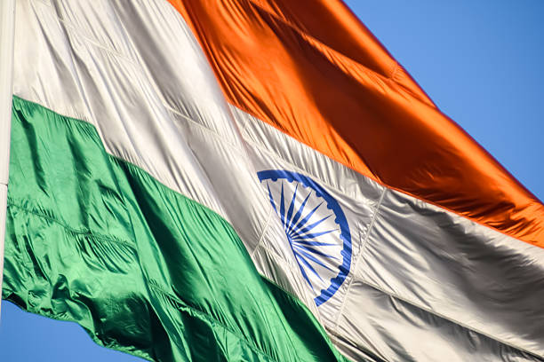 istock India flag flying high at Connaught Place with pride with plain white background, India flag fluttering, Indian Flag on Independence Day and Republic Day of India, tilt up shot, Har Ghar Tiranga 2229660537