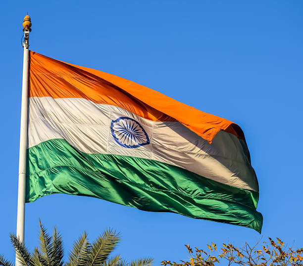 istock India flag flying high at Connaught Place with pride with plain white background, India flag fluttering, Indian Flag on Independence Day and Republic Day of India, tilt up shot, Har Ghar Tiranga 2229660595
