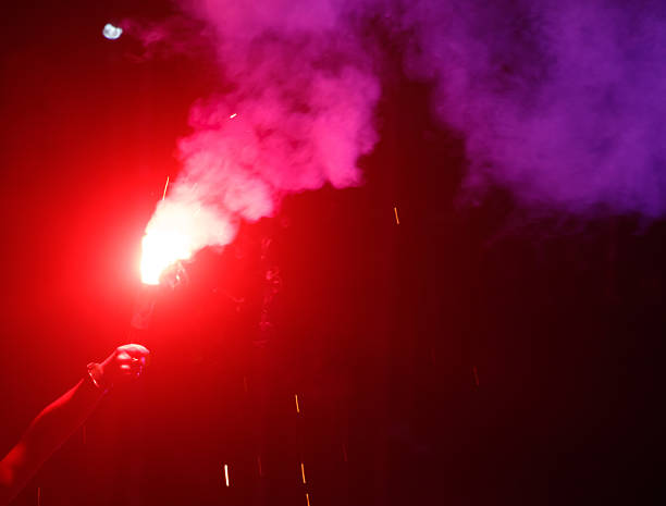 A person is holding a red torch in a dark room