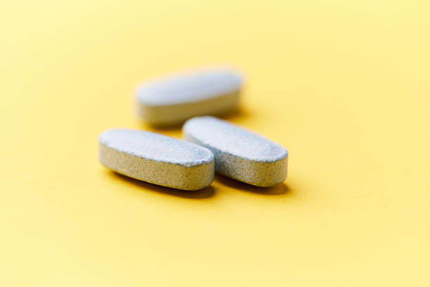 istock Multivitamin tablets on bright paper background. Close up. Copy space. 2229664634