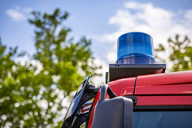 A close-up of a red fire truck highlights the flashing light on top, emitting a bright, pulsating glow to signal the truck’s presence in emergencies