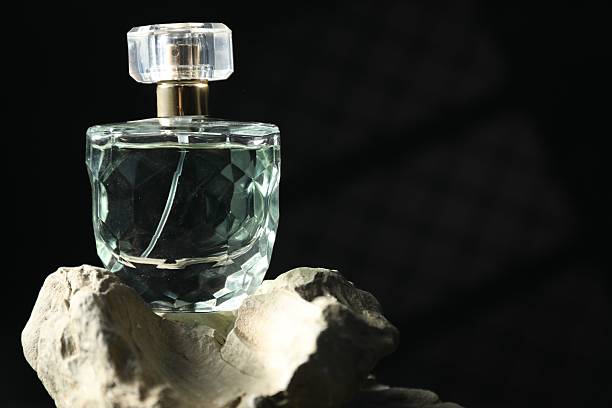 istock Bottle of fragrant perfume on rock against dark background, space for text 2229664804